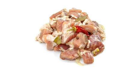 Raw pieces of pork shish kebab in marinade with pepper, onion,bay leaf, ready to cook, barbecue meat, isolated on a white background.
