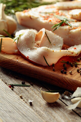 Lard with spices and herbs on a old wooden table.
