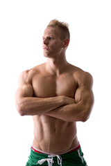 Fototapeta premium Shirtless muscular young man standing with arms crossed on chest, looking away to a side, isolated on white