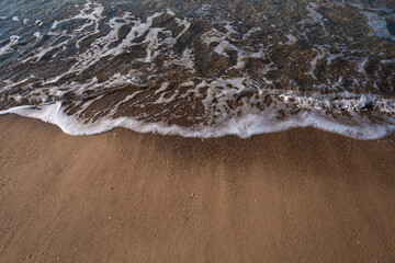 Seascape. Waves running on the sandy shore. Shore of the sea or ocean on a nice day. Vacation and relaxation by the sea.