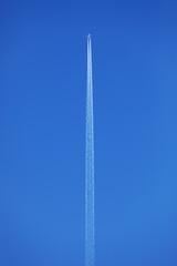 Aircraft with condes stripes against a blue sky