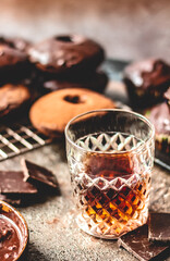 Whiskey on a background of chocolate donuts and the chocolate.
