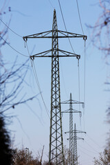 Electricity pylons against blue sky