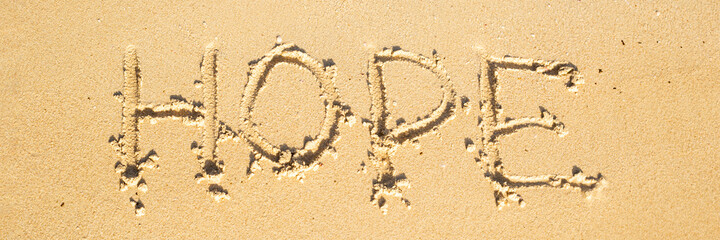 Hope inscription on the sand of the beach on a sunny day. Top view. Banner.