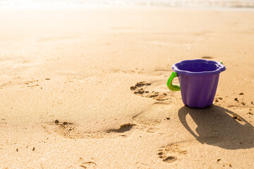 Fototapeta na wymiar plastic toy bucket on the sand on a sunny day.