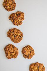 scattered homemade oatmeal cookies on a white background. Sweet diet oatmeal treat. vertical.