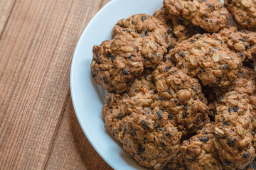 plate with homemade oatmeal cookies on a wooden table. Sweet diet oatmeal treat.