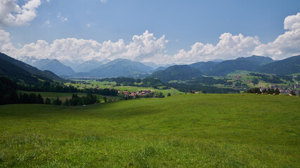 Fototapeta na wymiar Blick vom Aussichtspunkt Buchenhain bei Schöllang über das sommerliche südliche Illertal auf die Allgäuer Alpen