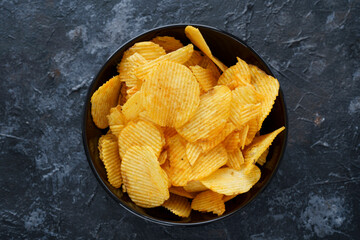 a cup of chips, on a dark background, fluted chips