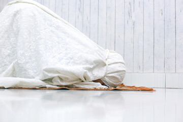 Muslim woman doing Salat with prostration pose on the prayer mat