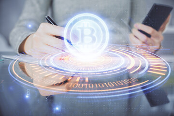Double exposure of blockchain business sketch hologram and woman holding and using a mobile device.