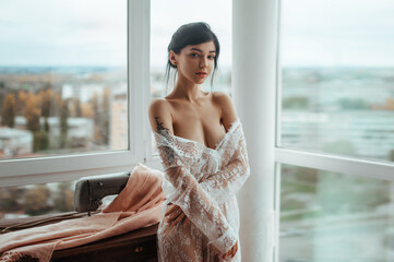 portrait of a beautiful woman in a white transparent tunic with a tattoo on her shoulder