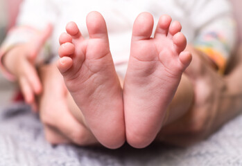 Obraz na płótnie Canvas small pink feet of the baby close up