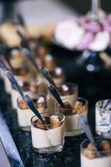 Candy bar at the wedding with lots of different cupcakes, soufflés and pastries. The interior is decorated in brown colors..