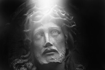 Close up eyes full of pain. Fragment of an ancient statue of  Jesus Christ crown of thorns ....