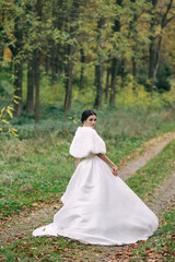 Portrait of a beautiful bride in a wedding dress with a long tra