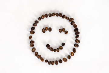 Artificial smiling face made from coffee beans on white background. Concept idea, copy space.