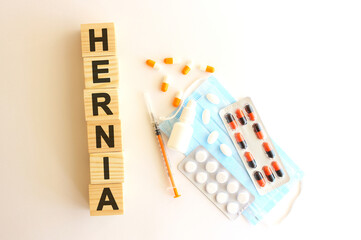 The word HERNIA is made of wooden cubes on a white background. Medical concept.