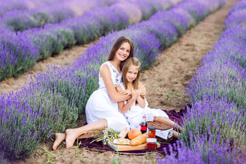 Summer picnic in nature. The older sister hugs the younger one.