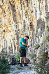 Climber with climbing equipment preparing for climbing.