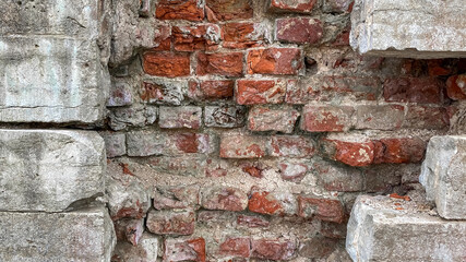 Concrete wall inside a red brick. Hole in the wall. The cement blocks are destroyed. Dismantling the wall.