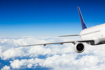 Fototapeta na wymiar Detail of jetplane wing flying above clouds