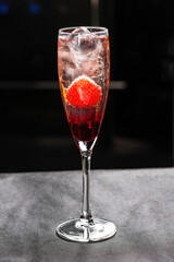 Champagne cocktail with liqueur and strawberries.Isolated on a black background
