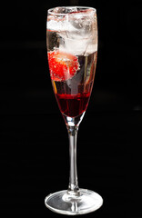 Champagne cocktail with liqueur and strawberries.Isolated on a black background