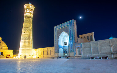 night view of east town buildings with minaret and moon over it 