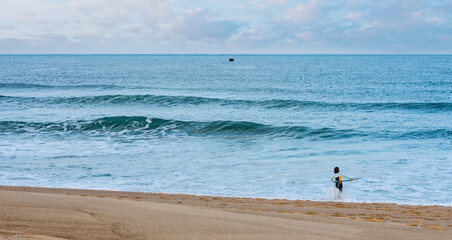 Fototapeta na wymiar surfer girl at dawn on the beach