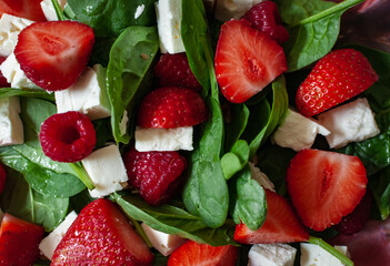 Delicious fresh organic spinach leaves strawberry salad with feta cheese and raspberry balsamic vinegar. Top view. Healthy food. 