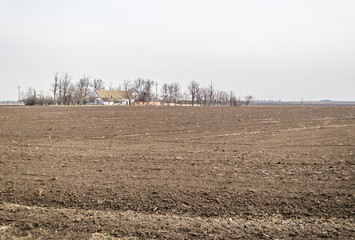 Panorama of prepared arable land with the Farmer's house in the spring 