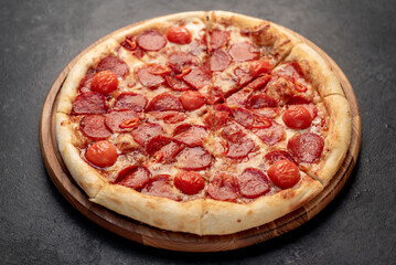pepperoni pizza with ingredients on stone background