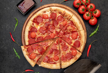 pepperoni pizza with ingredients on stone background