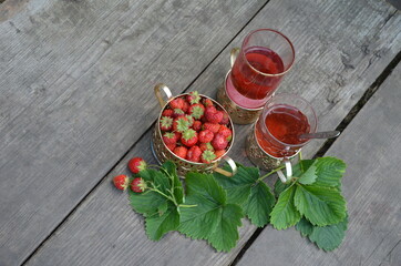 Berry strawberry tea and fresh garden strawberries on wooden background