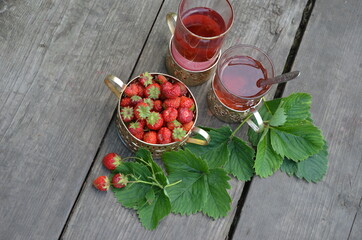 Berry strawberry tea and fresh garden strawberries on wooden background