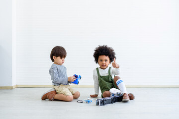 Fototapeta premium Black children and white children play with toys and have fun. Concept of apartheid And racism.