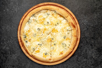 four cheese pizza with ingredients on stone background