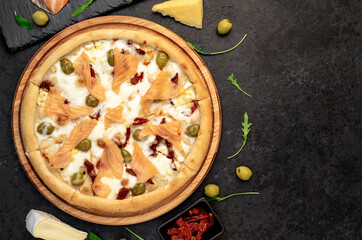 pizza with salmon, cheese and olives on a stone background  with copy space for your text