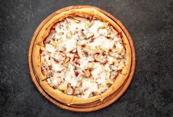 pizza with chicken, mushrooms and pineapple on a stone background