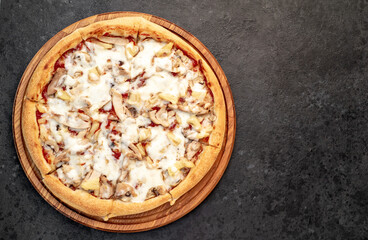 pizza with chicken, mushrooms and pineapple on a stone background  with copy space for your text