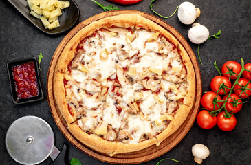 pizza with chicken, mushrooms and pineapple on a stone background