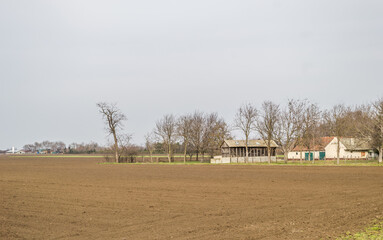 Panorama of prepared arable land with the Farmer's house in the spring 