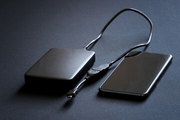 A smartphone and an external hard drive with an OTG cable and an adapter for connecting to gadgets...