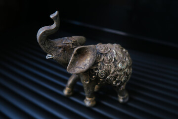 Fototapeta premium Golden elephant figurine on black background
