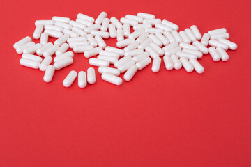 White pills on the red paper background. Epidemic virus.