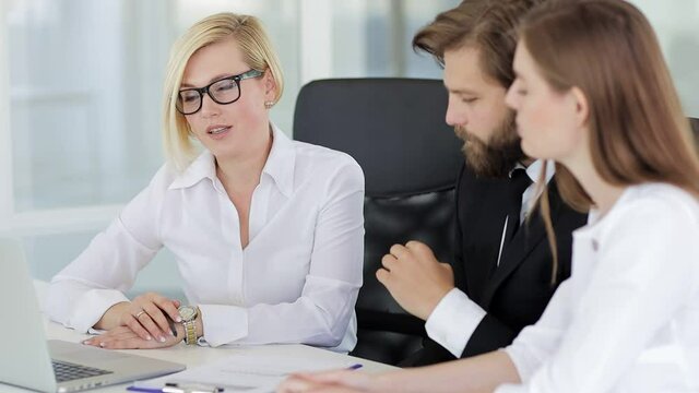 Confident female leader negotiating with business group explaining contract benefits at formal board meeting consulting corporate clients presenting commercial offer sit at conference office table