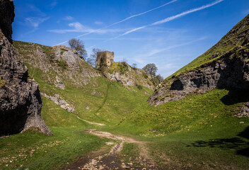 Sinister abandoned castle on top of a hill with lawn and trees around it