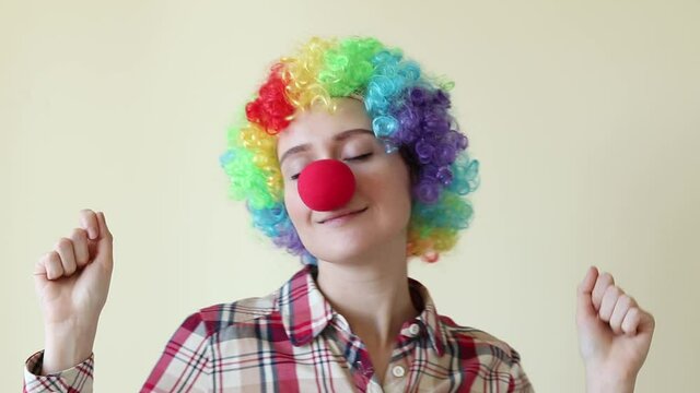 Girl in colored clown wig dancing, April fools day concept. High quality FullHD footage