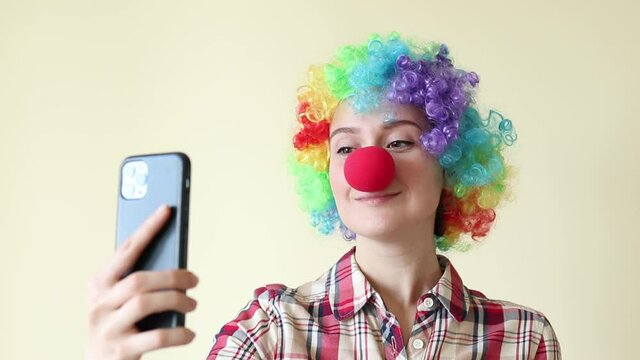 Woman in clown color wig taking selfie, funny fools day. High quality FullHD footage